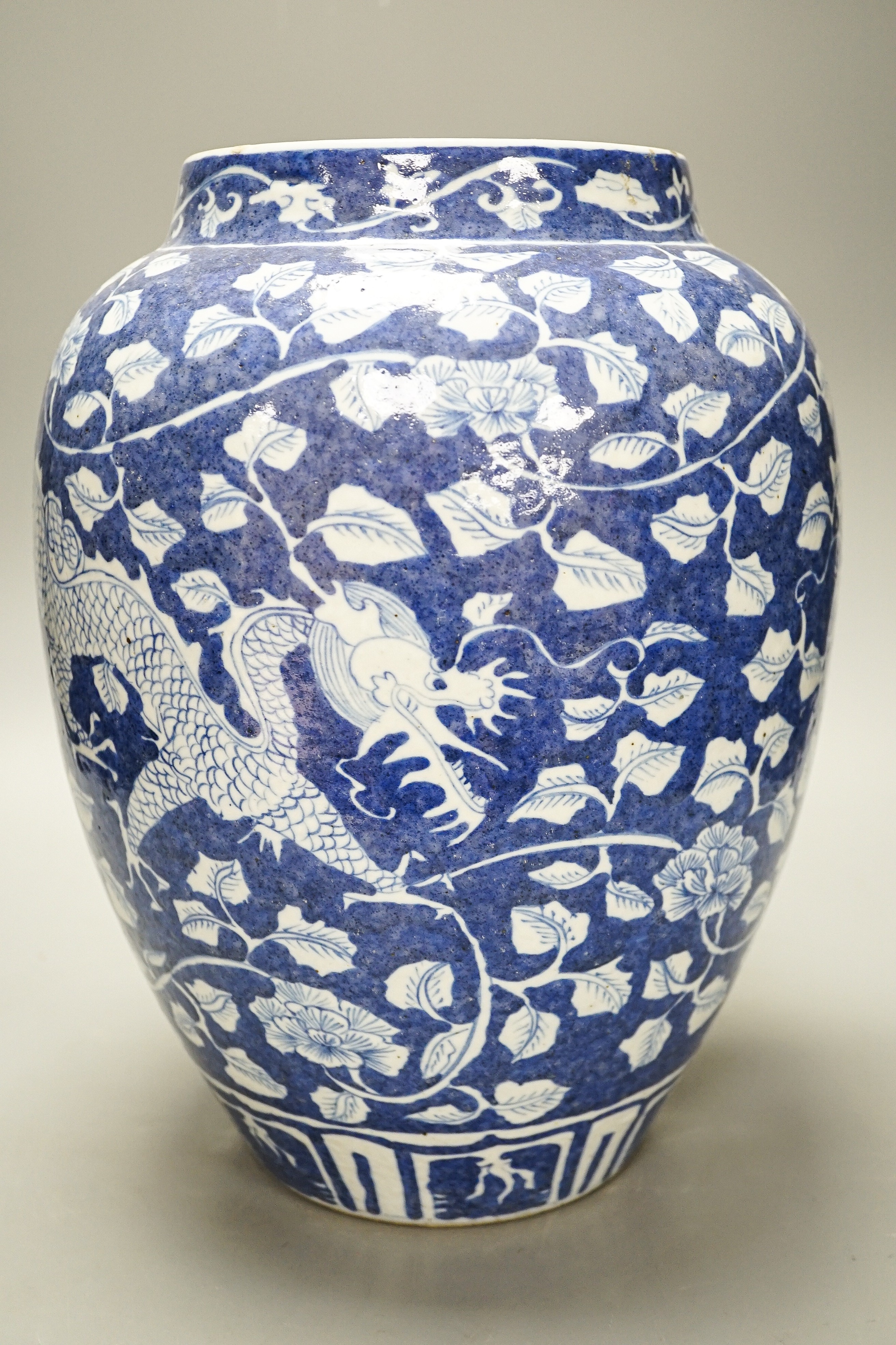 A Chinese blue and white ovoid jar, 19th/20th century, painted with dragons amid flowers and foliage, 33 cms high.